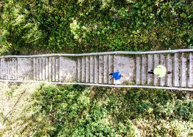 Aerial view of two runners jogging on dirt running trail. Morning running training for two male friends. clipart