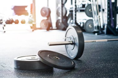 Zeminde metal halterler ve spor salonunda dayanıklılık eğitimi için askılar var..