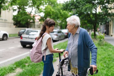 Büyükanne, torununa okula gitmeden önce güvenli bir şekilde scooter sürmeyi anlatıyor..