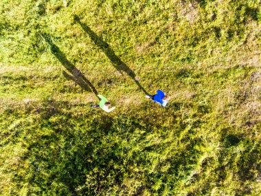 Doğadaki toprak yolda koşan iki koşucunun hava görüntüsü. İki erkek arkadaş için sabah antrenmanı..