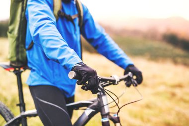 Genç bir adam güzel bir sonbahar sabahının ortasında bisikletle dinleniyor. Aktif ve sağlıklı yaşam tarzı kavramı.