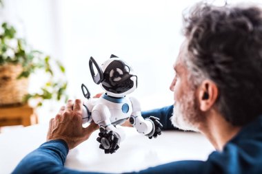 İnsan sevimli robot köpeğe bakıyor..