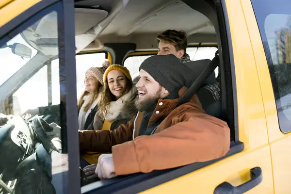 stock image Friends traveling by car on winter holiday, spending Christmas in a cabin. Driving through a snowy landscape.