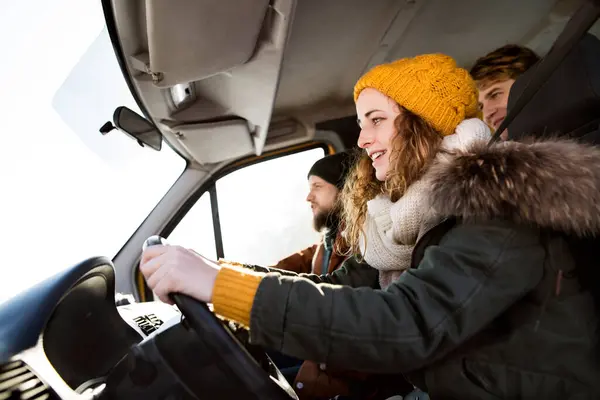 stock image Friends traveling by car on winter holiday, spending Christmas in a cabin. Driving through a snowy landscape.