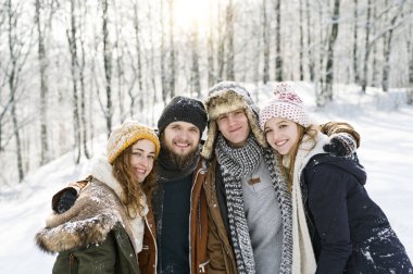 Group of friends on a walk in the snowy nature. First snow of the season clipart