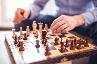Dedem küçük çocuğa satranç oynamayı öğretiyor. Büyükbaba torunuyla vakit geçirir, ailesi işteyken ona bakar.