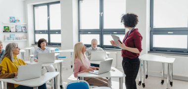 Öğretmen son sınıf öğrencilerine kendi işlerini nasıl kuracaklarını anlatıyor. Bilgisayar ve teknoloji eğitimine katılan yaşlılar. Yaşlılar için girişimcilik programı