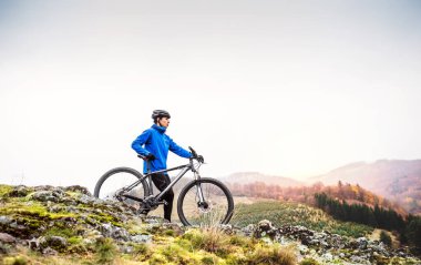 Güzel doğanın ortasında bisiklete binen aktif bir adam aktif ve sağlıklı yaşam tarzının güzel manzarasının tadını çıkarıyor..