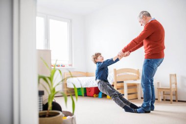 Büyükbaba torunuyla oynuyor, el ele tutuşuyor ve çemberin etrafında dönüyor. Eğleniyorum.