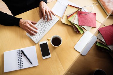 Merkez ofis kurulumu, yüksek açı manzarası. Evden bilgisayarda çalışan, klavyede yazan bir adam. Uzak çalışma.