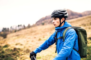 Bisikletli aktif bir adam güzel bir doğanın ortasında, güzel manzaranın tadını çıkarıyor. Aktif ve sağlıklı yaşam tarzı kavramı.