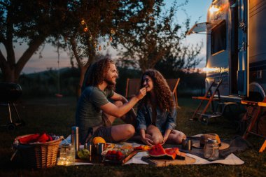Çiftler doğada kamp yaparken romantik piknik yapıyorlar. Adam kız arkadaşını besliyor. Kervan gençler için yola çıktı.