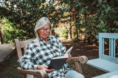 Güzel yaşlı kadınlar bahçede sallanan sandalyede oturmuş kitap okuyorlar. Kadın kıdemli evde huzurlu bir anın tadını çıkarıyor, özgürlüğünün tadını çıkarıyor..