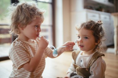 Erkek kardeş burun sümüğünü temizlemek için burun emme ampulü kullanıyor.