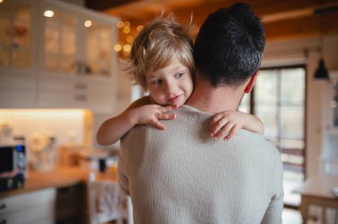 Babası küçük oğlunu kollarında tutuyor, ona sarılıyor. Babalık ve Babalar Günü konsepti.
