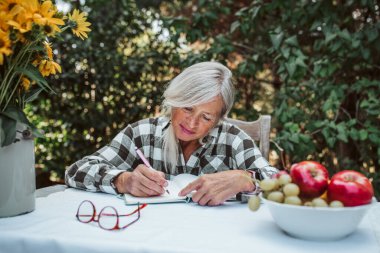 Güzel yaşlı kadınlar bahçede oturuyor ve günlüğünü yazıyorlar. Yaşlı kadın günlük tutuyor, düşüncelerini ve duygularını yazıyor.