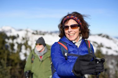 Karlı kış doğasında yürüyen aktif yaşlılar. Karlı dağlarda yaşlı bir çift için romantik kış yürüyüşü