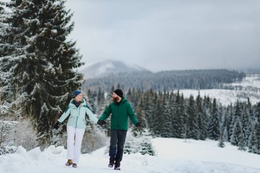 Karlı doğanın ortasında bir çift. Kış dağlarında yürüyüş..