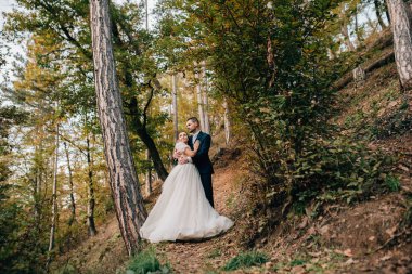 Ormanla çevrili güzel bir gelin ve zarif bir damat portresi..