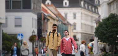 Down sendromlu genç bir adam ve akıl hocası arkadaşı şehirde yürüyor ve konuşuyorlar..