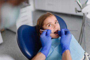 Diş sağlığı kliniğinde her yıl yapılan diş muayenesi sırasında tatlı bir genç kız..