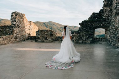 Kar beyazı gelinlik içinde kısa kollu ve uzun peçeli göz kamaştırıcı bir gelin..