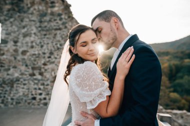 Güzel bir gelini öpen bir kocanın portresi. Romantik düğün anı.