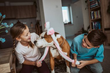 Erkek, kız ve köpek tavşan kulaklığı takıyor. Aile Paskalya Bayramı konsepti.