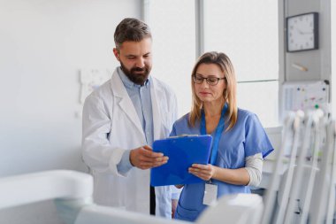 Doktor ve bayan hemşire test sonuçlarına panoda bakıyorlar. Doktorların ofisinde, klinikte sağlık çalışanları.