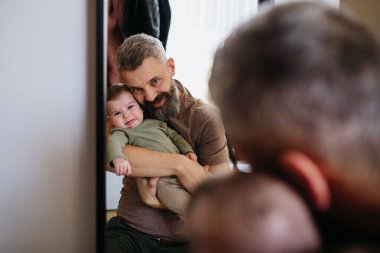 Baba ağlayan oğlunu teselli ediyor, onu kollarına alıyor..
