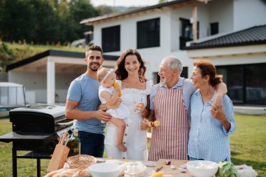 Üç nesildir aile bahar hafta sonu barbeküsü için yemek hazırlıyor. Bahçe partisi.