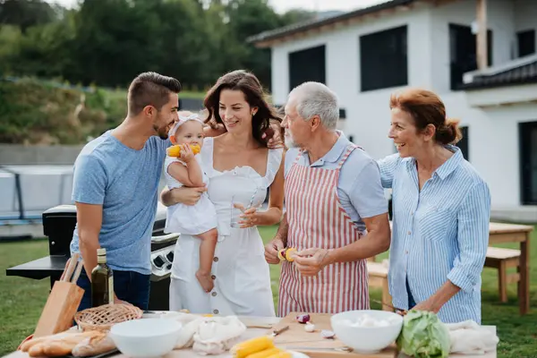 Üç nesildir aile bahar hafta sonu barbeküsü için yemek hazırlıyor. Bahçe partisi.