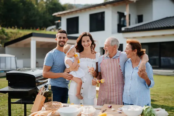 Üç nesildir aile bahar hafta sonu barbeküsü için yemek hazırlıyor. Bahçe partisi.