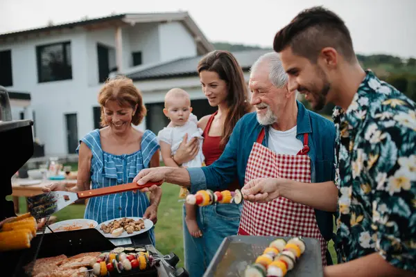 Üç nesildir aile bahar hafta sonu barbeküsü için yemek hazırlıyor. Bahçe partisi.