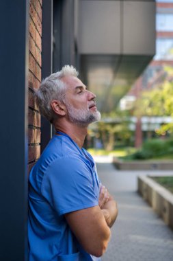 Hüsrana uğramış ve bitkin düşmüş bir doktor, hastanenin dışında dikilip kendini kötü hissediyor. Ruh sağlığı sorunları.