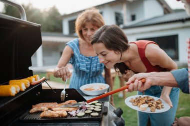 Aile hafta sonu barbekü partisi için yemek hazırlıyor. Bahçe partisi.