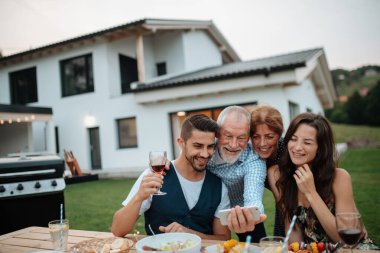 Aile bahar barbeküsü sırasında selfie çekiyor. Aile bahçesi partisi.