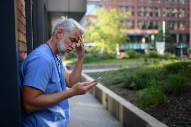 Hüsrana uğramış ve bitkin düşmüş bir doktor, hastanenin dışında dikilip kendini kötü hissediyor. Ruh sağlığı sorunları.