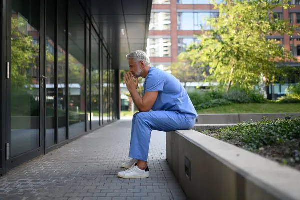 Hüsrana uğramış ve bitkin düşmüş bir doktor, hastanenin dışında dikilip kendini kötü hissediyor. Ruh sağlığı sorunları.