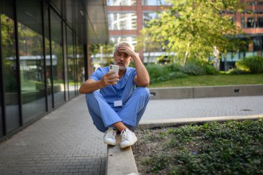 Hüsrana uğramış ve bitkin düşmüş bir doktor, hastanenin dışında dikilip kendini kötü hissediyor. Ruh sağlığı sorunları.