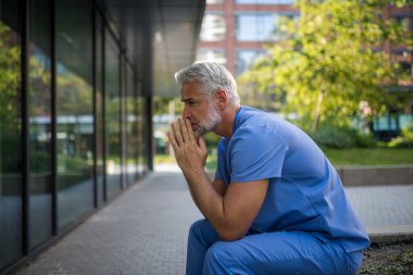 Hüsrana uğramış ve bitkin düşmüş bir doktor, hastanenin dışında oturmuş, kendini kötü hissediyor. Ruh sağlığı sorunları.