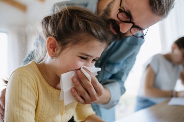 Babası kızının tıkanmış burnunu silmesine yardım ediyor..