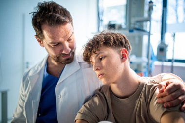 Şefkatli doktor ameliyattan önce endişeli bir genç hastayı destekliyor. Depresyondaki gençler için zihinsel sağlık değerlendirmesi.