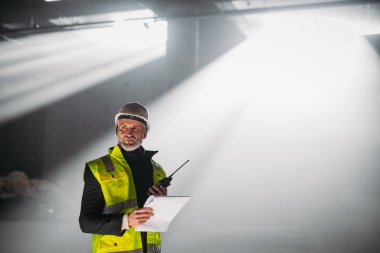 İnşaat ustası bina teftişi sırasında telsizden talimat veriyor..