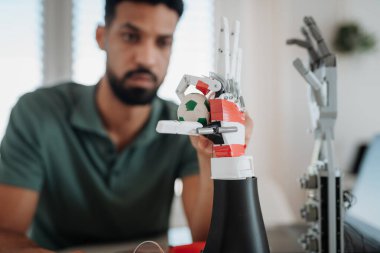 Genç mühendis evde bir robotik kol yapıyor ve programlıyor. Robot konsepti.