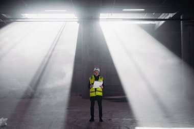 İnşaat ustası bina teftişi sırasında telsizden talimat veriyor..