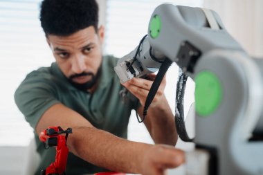Genç mucit ev teknolojisi projesinin bir parçası olarak robotik kol geliştiriyor. Robot konsepti.