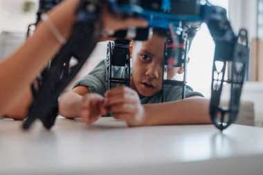 STEM öğreniminin bir parçası olarak evde robot araba üretmeye ve programlamaya odaklanmış çocuk..