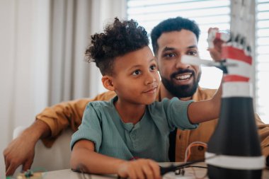 Baba oğluna BTMM, robot bilimi öğretiyor ve evde teknolojiyi tartışıyor..