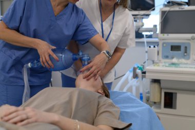 Hastane personeli, hastanedeki baygın genç kıza oksijen maskesi takıyor. Tıbbi prosedür.